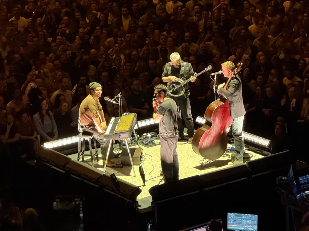 Concert: a band playing on a small stage with a packed crowd behind